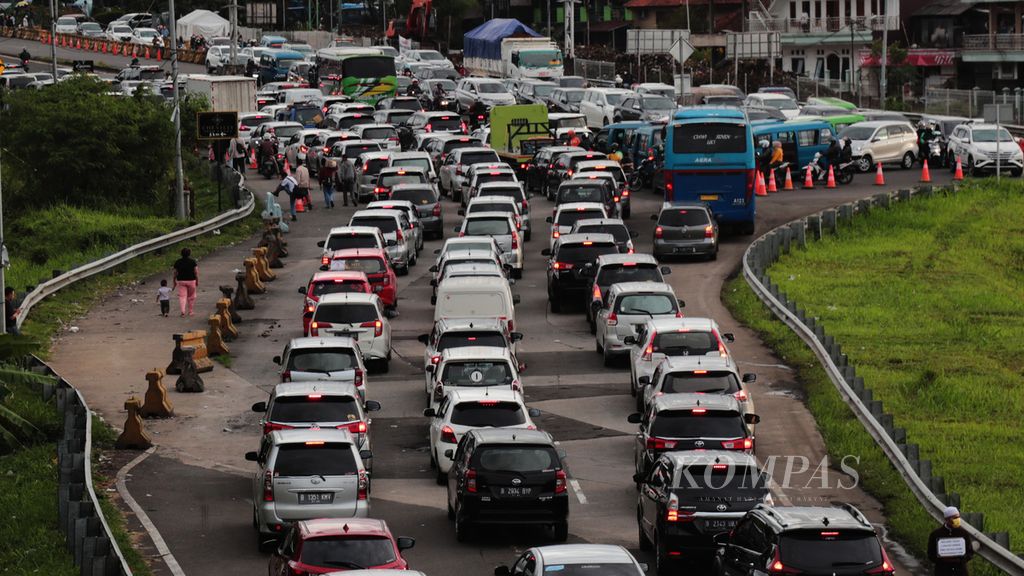 Kemacetan lalu lintas saat keluar Tol Jagorawi di jalur keluar menuju Persimpangan Ciawi, Kabupaten Bogor, Jawa Barat, yang dipadati kendaraan menuju Puncak, Minggu (27/2/2022). Sering kita memakai frasa <i>terjebak kemacetan</i> dalam kondisi seperti ini, padahal hal itu tidak tepat.