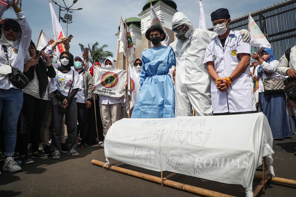 Aksi teatrikal dalam aksi menolak pengesahan Rancangan Undang-Undang Kesehatan di depan Kompleks Parlemen, Jakarta, Selasa (11/7/2023).