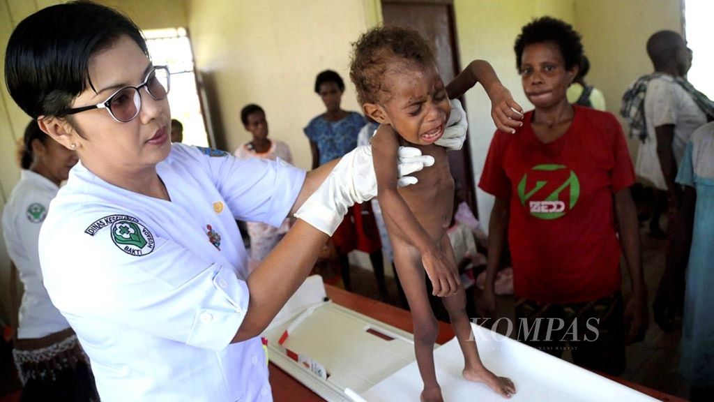 Medical officer Tuti Handayani from the Sawa Erma Community Health Center examines the condition of Yuvensias Tombitan (2) who weighs 5.8 kilograms during a child and maternal health examination at the Sawa Village Health Post, Sawa Erma District, Asmat Regency, South Papua on Monday (15/1).