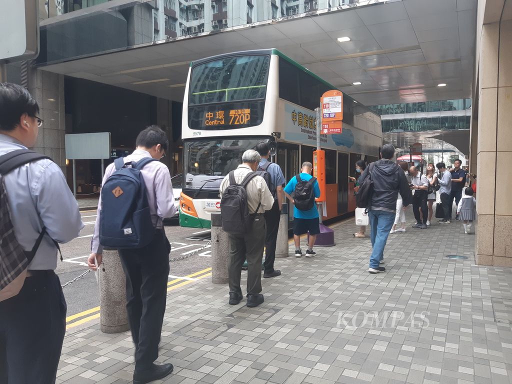 Warga mengantre masuk dalam bus di kawasan Taikoo Shing, sebelah timur kota Hong Kong, Senin (25/3/2024). 