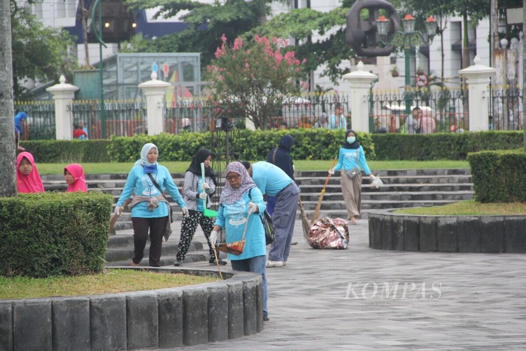 Sejumlah anggota Komunitas Clean The City membersihkan sampah sisa perayaan Tahun Baru 2019 di halaman Monumen Serangan Umum 1 Maret, Kota Yogyakarta, Selasa (1/1/2019) pagi.