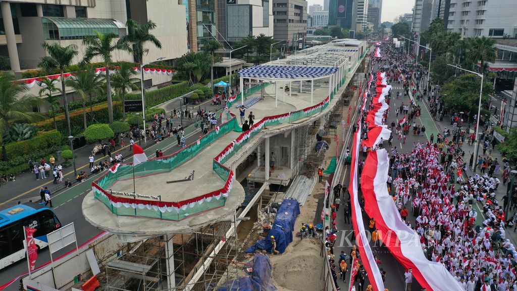  Aerial photo of residents attending the Red and White Parade at the Hotel Indonesia Roundabout, Central Jakarta, Sunday (28/8/2022). The Red and White Carnival was released by President Joko Widodo who was accompanied by the National Police Chief General Listyo Sigit Prabowo from the Merdeka Palace and circled at the Hotel Indonesia roundabout.