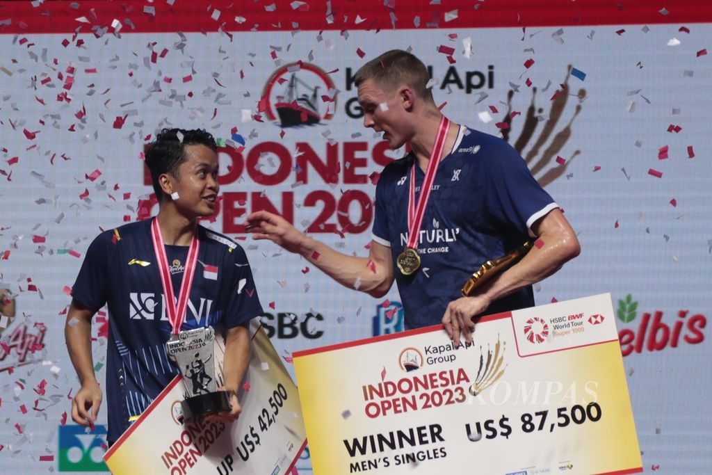 Badminton player from Denmark, Viktor Axelsen (right), and Indonesian badminton player, Anthony Sinisuka Ginting, received the championship and runner-up trophies after the final match of the 2023 Indonesia Open at Istora Gelora Bung Karno, Jakarta, on Sunday (18/6/2023). Of their 16 meetings, Axelsen has won 12 times.