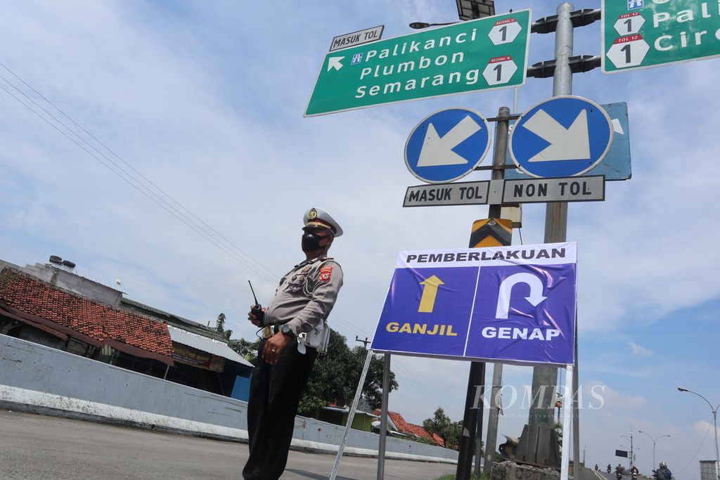 Polisi menyeleksi kendaraan sesuai sistem ganjil genap di pintu masuk Tol Palimanan-Kanci, Kabupaten Cirebon, Jawa Barat, Rabu (27/4/2022). 