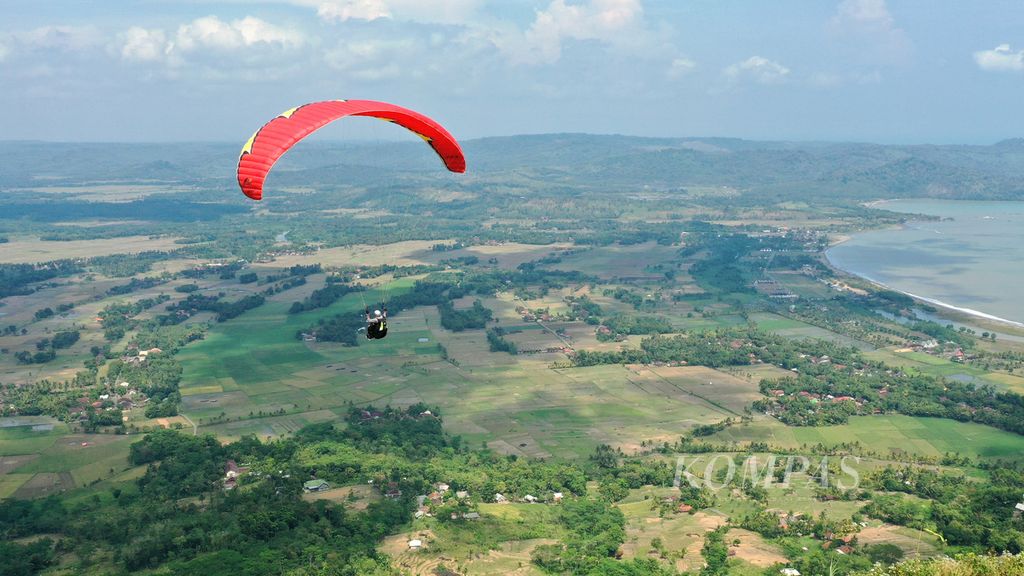 Figo (22) paragliding pilot swaying in the Ciletuh-Palabuhanratu Geopark area, Ciemas Village, Sukabumi Regency, Thursday (4/8/2022).