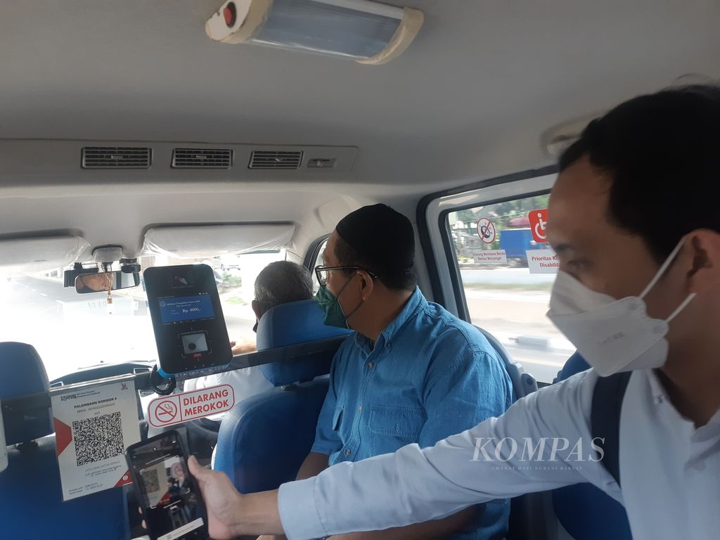 Seorang penumpang angkutan pengumpan (feeder) kereta ringan (Light Rail Transit/LRT) Palembang, Sumatera Selatan, melakukan pembayaran secara digital, Senin (26/12/2022).