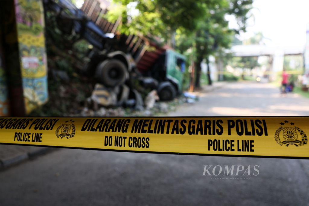 Garis polisi dipasang di sekitar lokasi kecelakaan truk kontainer yang mengalami kecelakaan dan keluar dari Jalan Tol Jakarta-BSD, Serpong, Tangerang Selatan, Senin (27/4/2021). Truk terperosok dan tertahan pohon di pinggir Jalan Batam. Sopir truk luka-luka dan saat ini sedang diperiksa polisi untuk mengetahui penyebab kecelakaan. Kecelakaan terjadi sekitar pukul 02.30 dini hari. Hingga pukul 10.00 truk belum dievakuasi. 
