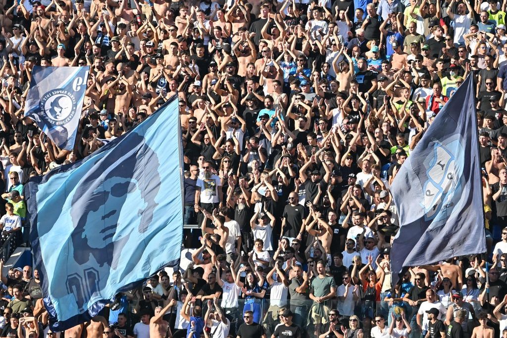 Suporter Napoli bersorak untuk mendukung timnya dalam pertandingan Liga Italia antara Napoli dan Sassuolo di Stadion Diego Armando Maradona, Napoli, Sabtu (29/10/2022). Napoli mengalahkan Sassuolo, 4-0. 