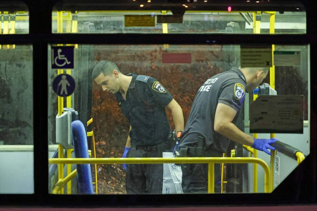 Dua polisi Israel memeriksa kabin bus setelah serangan di luar Kota Tua Jerusalem, Minggu (14/8/2022). 