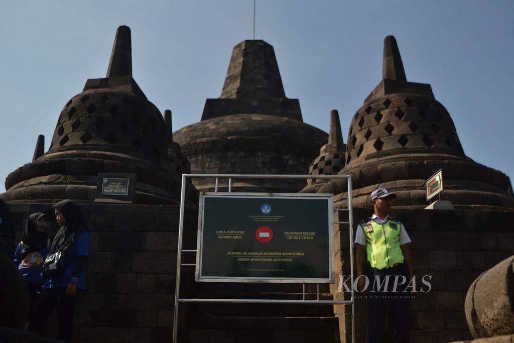 Petugas satpam berjaga untuk memperingatkan pengunjung yang menaiki stupa di lantai delapan Candi Borobudur, Magelang, Jawa Tengah, Kamis (13/2/2020).