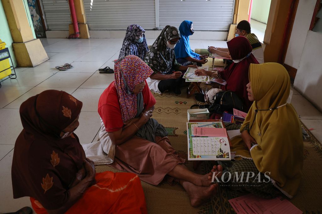 Buruh gendong mengikuti kegiatan pelatihan membaca Al-Quran di Pasar Beringharjo, Yogyakarta, Jumat (8/4/2022). Pelatihan untuk buruh gendong tersebut digelar setiap bulan Ramadan.