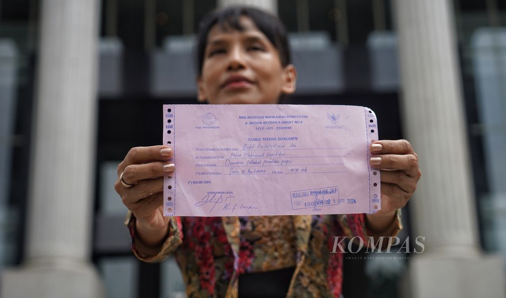  Ayu Utami menunjukkan bukti penyerahan surat <i>amicus</i><i>curiae</i> para seniman dan budayawan di Mahkamah Konstitusi, Jakarta, Senin (1/4/2024). 