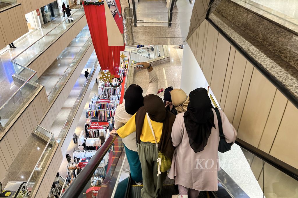 Remaja putri berswafoto di eskalator di sebuah pusat perbelanjaan di kawasan Blok M, Jakarta Selatan, Senin (9/1/2023). Pusat perbelanjaan yang menawarkan beragam keperluan masih menjadi tujuan masyarakat.