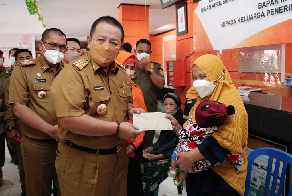 Gubernur Lampung Arinal Djunaidi menyerahkan uang tunai program bantuan langsung tunai minyak goreng kepada penerima di Bandar Lampung, Selasa (12/4/2022). 