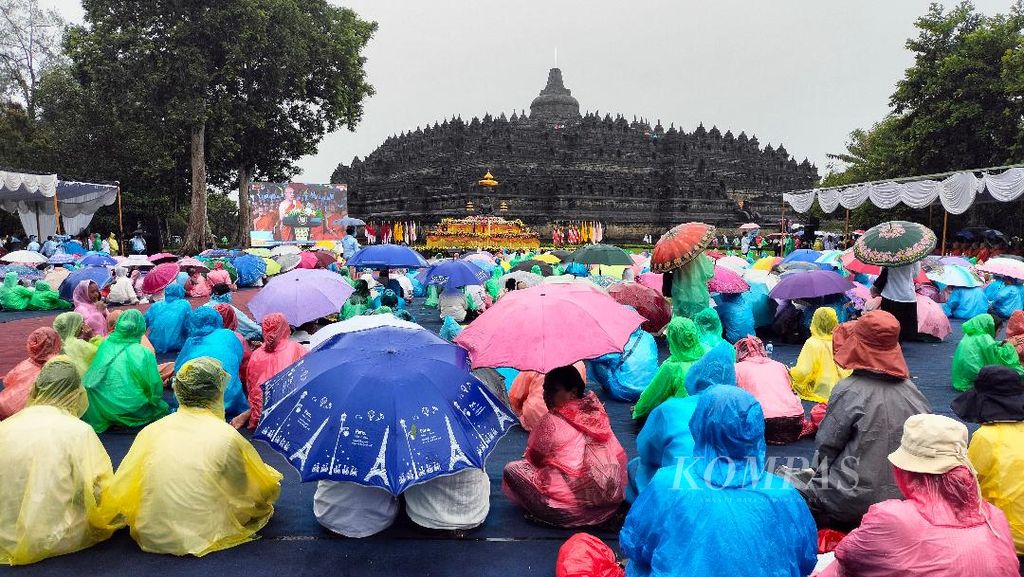 Perayaan Magha Puja di Candi Borobudur, Kabupaten Magelang, Jawa Tengah, Sabtu (9/3/2024), berlangsung di tengah guyuran hujan. Umat Buddha mengikuti perayaan dengan memakai payung dan jas hujan.