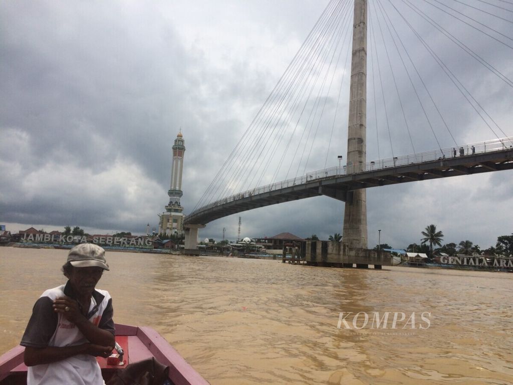 Pemilik perahu mengantar wisatawan menyeberangi Sungai Batanghari yang kini tercemar, Kota Jambi, Mei 2019.