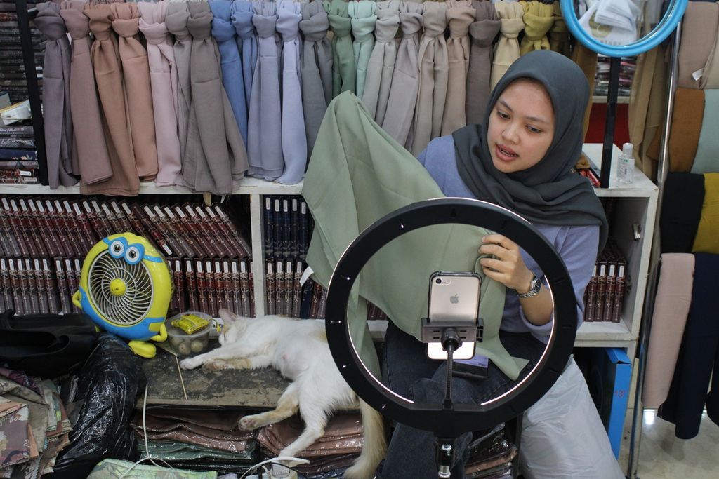 Seorang pramuniaga salah satu toko di pusat perbelanjaan Balubur Town Square, Kota Bandung, Jawa Barat, menjajakan produk dagangannya secara daring, Jumat (22/9/2023). 
