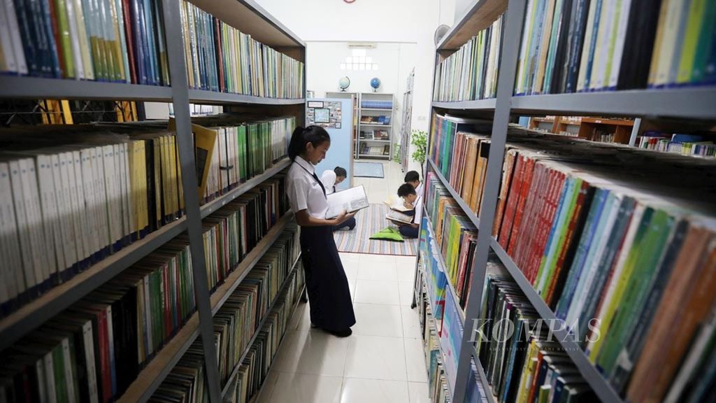 Para siswa memanfaatkan waktu luang di perpustakaan sekolah di SMPN 255, Jakarta, Selasa (4/12/2018). Peningkatan prestasi sekolah dan belajar siswa dapat dilakukan dengan mengoptimalkan perpustakaan sekolah. Sebagian tugas siswa saat ini juga masih terbantu dengan keberadaan perpustakaan sekolah selain melalui internet.