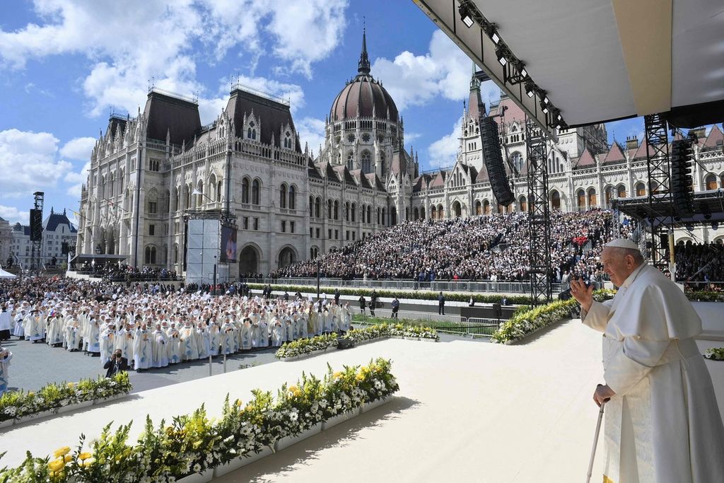 Paus Fransiskus melambaikan tangan kepada umat saat mempersembangkan ekaristi di Alun-alun Kossuth Lajos di Budapest, Hongaria, Minggu (30/4/2023).  