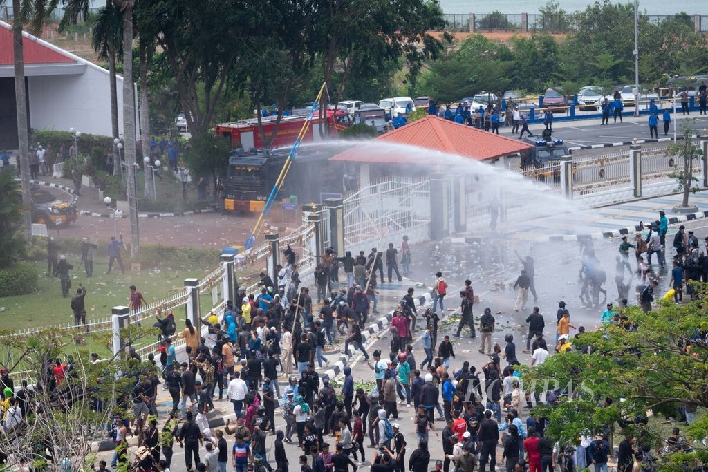 Polisi menggunakan mobil <i>water cannon</i> untuk memukul mundur massa yang melempar botol dan batu ke kantor Badan Pengusahaan Batam, Kepulauan Riau, Senin (11/9/2023).