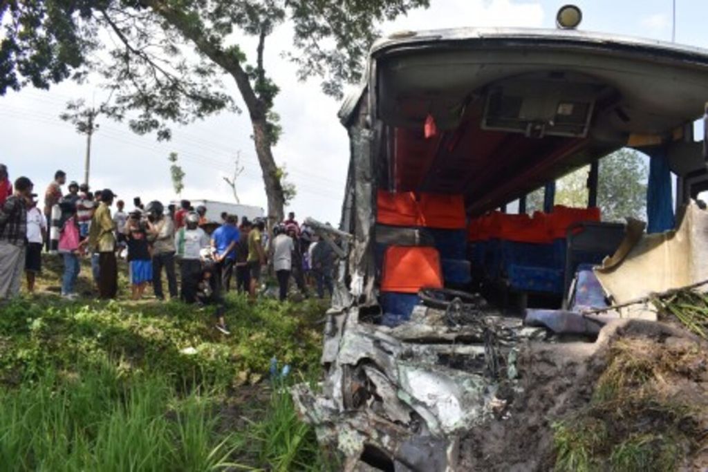 Sejumlah orang melihat Bus Eka jurusan Surabaya-Yogyakarta yang tercebur di sawah setelah tabrakan beruntun di Jalan Raya Ngawi-Yogyakarta di Desa Kawu, Kedunggalar, Ngawi, Jawa Timur, 17 April 2018.  