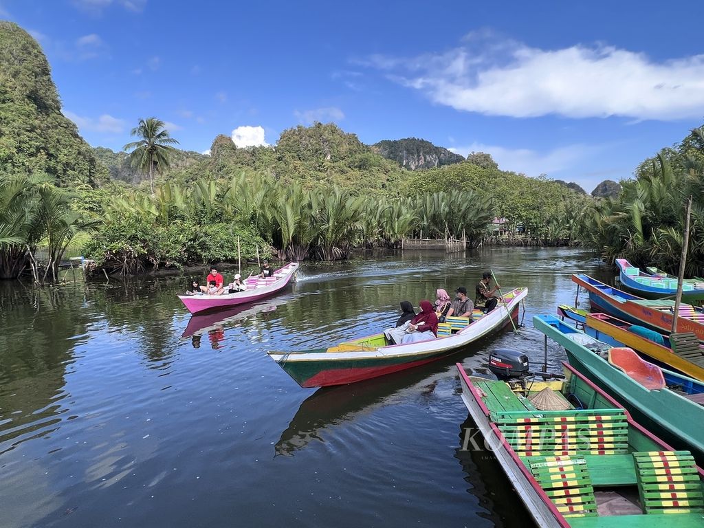 Wisatawan berperahu menyusuri Sungai Pute di obyek wisata Rammang-Rammang di Maros, Sulawesi Selatan, Sabtu (3/6/2023).