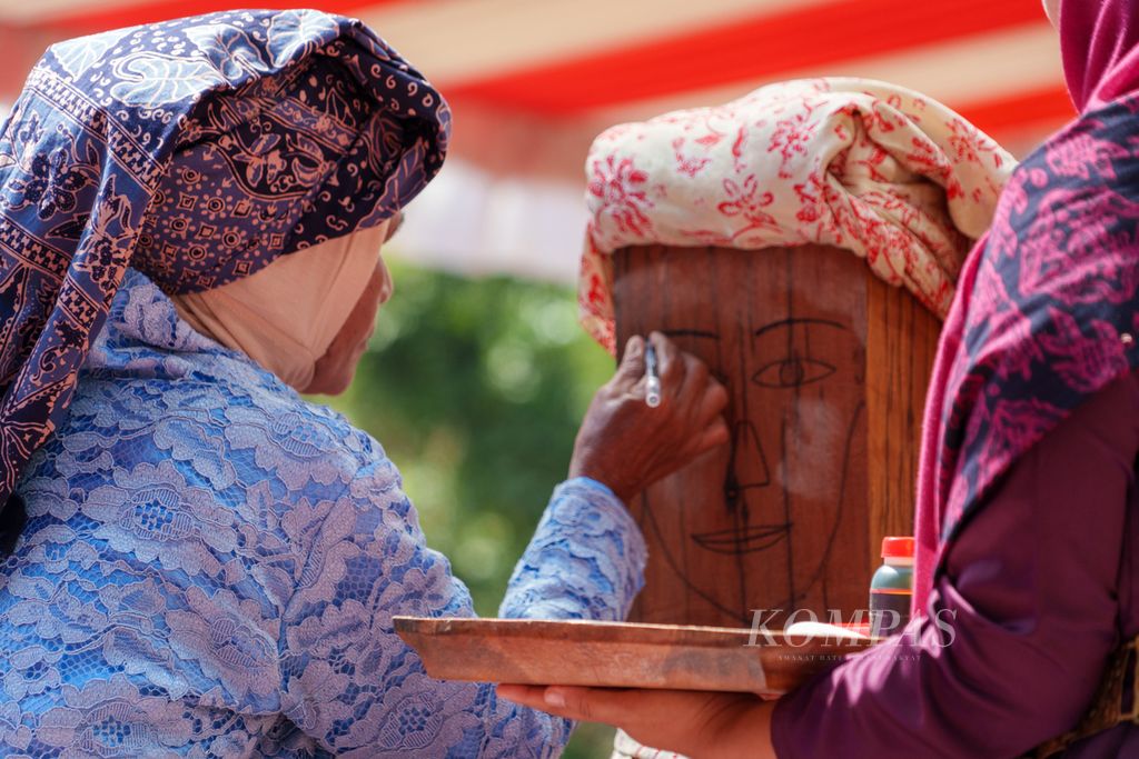 Tiang Tuo yang terbuat dari kayu bulian diberi hiasan dalam prosesi tradisi Tegak Tiang Tuo atau peletakan batu pertama pembangunan Museum KCBN Muarajambi di Desa Danau Lamo, Kecamatan Maro Sebo, Kabupaten Muaro Jambi, Jambi, Rabu (5/6/2024). 