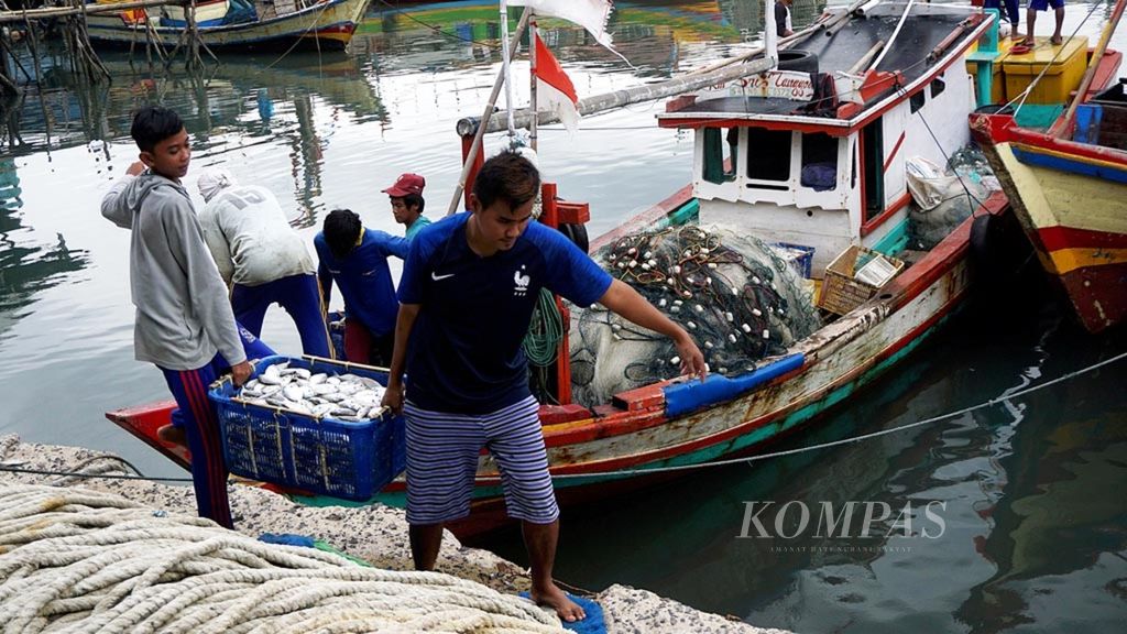 Nelayan mengangkat ikan dari perahu ke tempat pendaratan ikan Gudang Lelang, Bandar Lampung, Lampung, Rabu (23/1/2019). Gelombang tinggi dan angin kencang membuat nelayan membatasi daerah tangkapan. Tangkapan ikan juga kurang memadai.