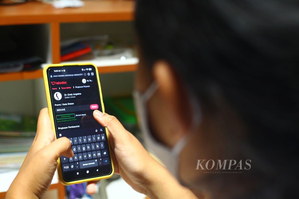 Penderita Covid yang menjalani isolasi mandiri memanfaatkan fasilitas <i>telemedicine </i>menggunakan telepon pintarnya dari rumahnya di Tangerang Selatan, Senin (31/1/2022). 