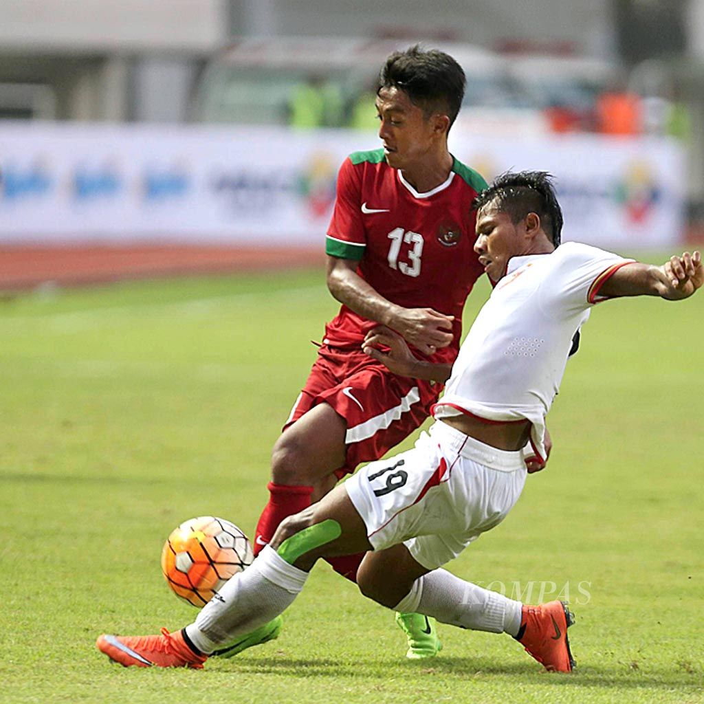 Pemain timnas  U-22, Febri Hariyadi (13), berebut bola dengan pemain timnas Myanmar, Thein Than Win, dalam laga uji coba di Stadion Pakansari, Cibinong, Kabupaten Bogor, Jawa Barat, Selasa (21/3). Timnas Indonesia harus mengakui kekuatan Myanmar setelah kalah dengan skor 1-3.