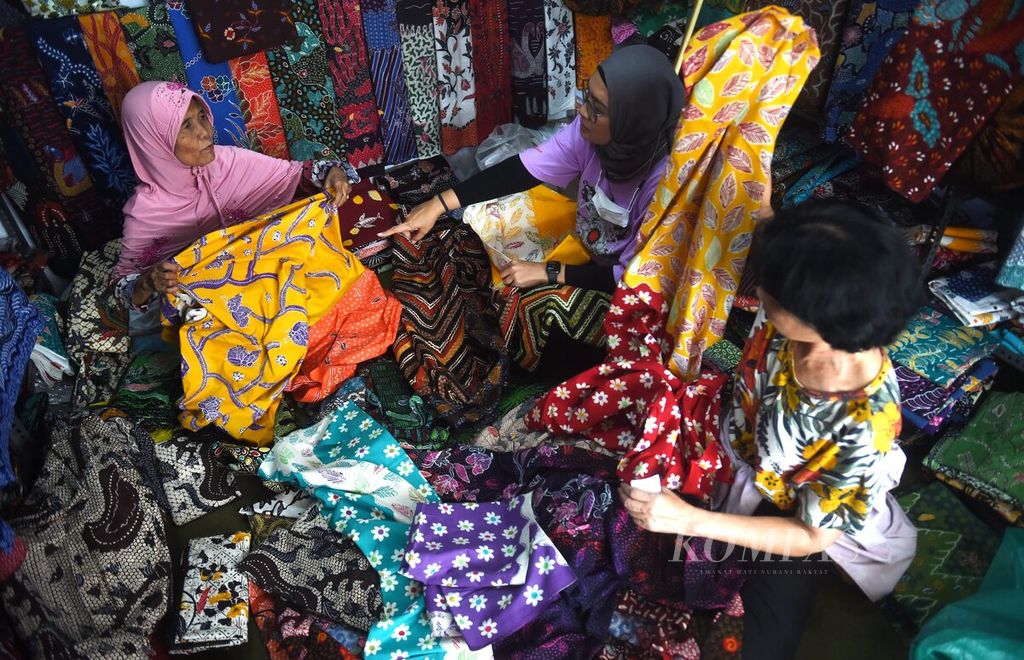 Aktivitas jual beli di Pasar Batik 17 Agustus, Pamekasan, Selasa (18/7/2023). Pasar Batik 17 Agustus menjadi tempat perajin batik khas Pamekasan menjual hasil kerajinan. Kain batik dijual dari harga Rp 50.000 hingga jutaan rupiah.  