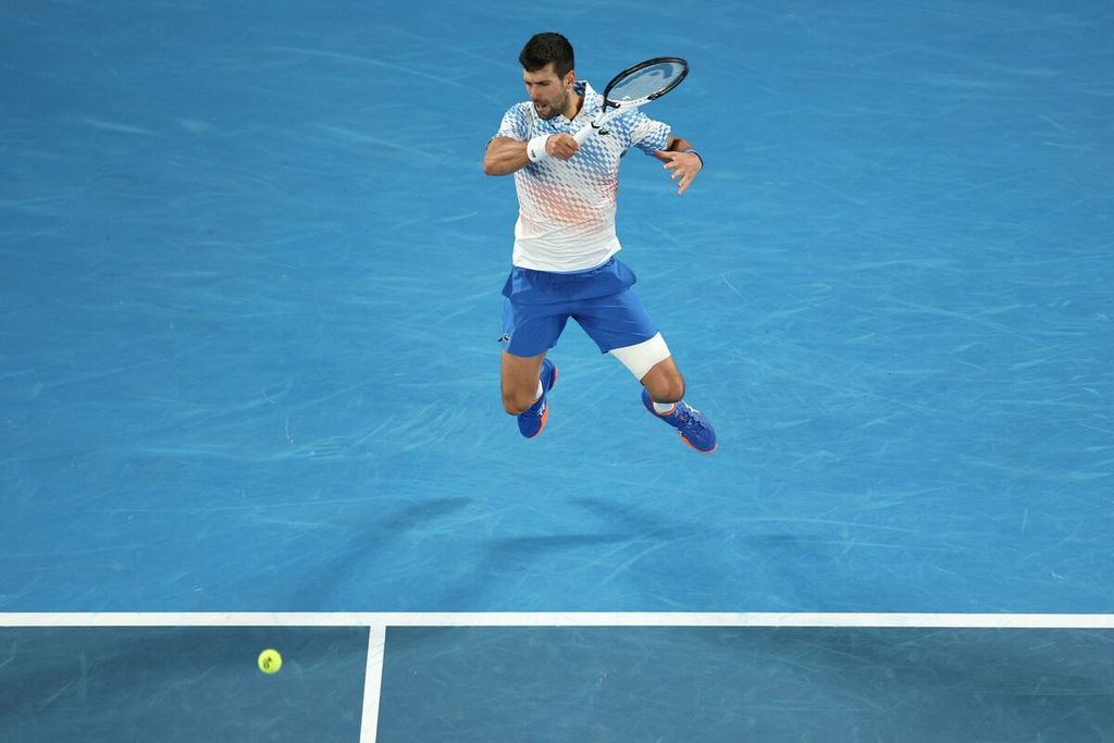 Novak Djokovic memukul bola saat melawan Andrey Rublev pada laga perempat final tunggal putra Grand Slam Australia Terbuka di Melbourne Park, Melbourne, Australia, Rabu (25/1/2023).
