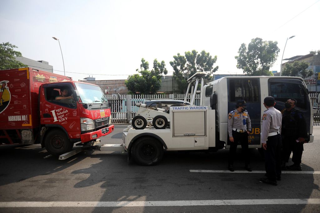 Mobil derek Suku Dinas Perhubungan Jakarta Timur menertibkan truk yang parkir di zona larangan di Jalan Matraman Raya, Jakarta Timur, Jumat (20/8/2021). Penertiban ini rutin dilakukan untuk menghindari kemacetan yang kerap terjadi karena parkir liar di sekitar ruas jalan tersebut.