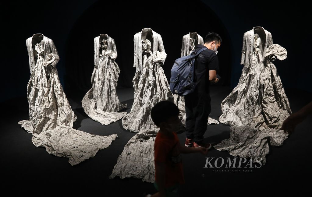 Pengunjung menikmati karya seni yang ditampilkan dalam pameran Artina Sarinah#1 di Sarinah Thamrin, Jakarta Pusat, Jumat (16/12/2022). 