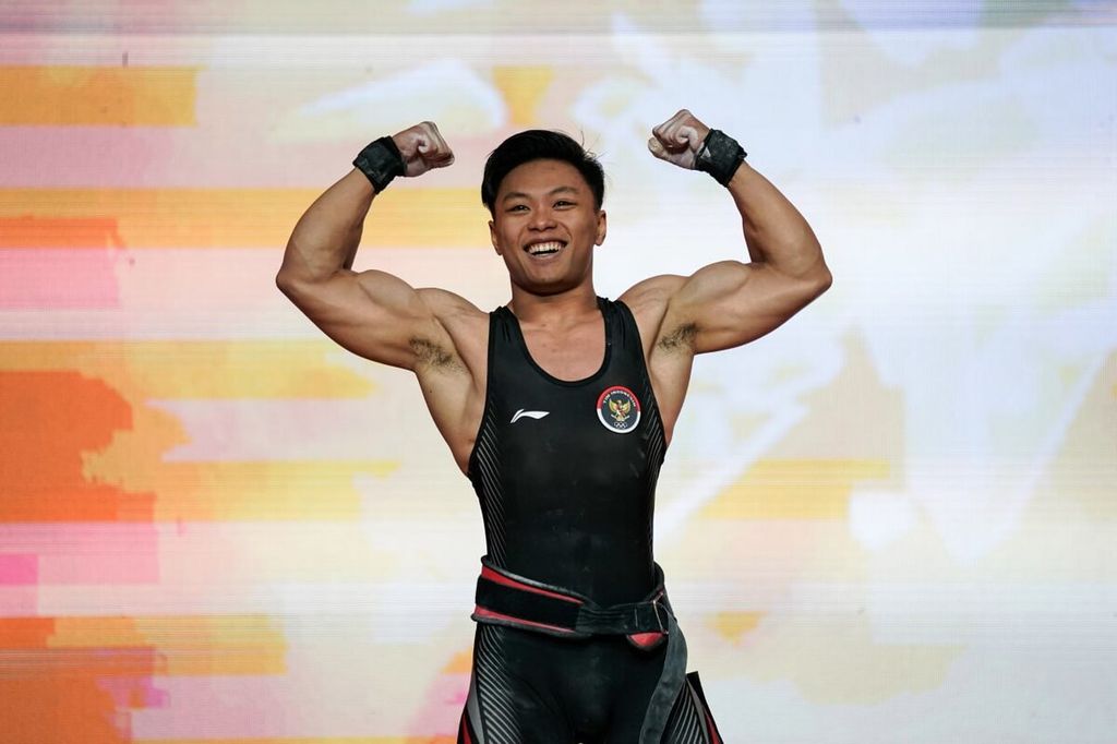 Lifter Indonesia, Rahmat Erwin Abdullah, berpose setelah berhasil memborong tiga medali emas dan menajamkan rekor dunia di Kejuaraan Angkat Besi Asia 2024 di Tashkent, Uzbekistan, Selasa (6/2/2024).