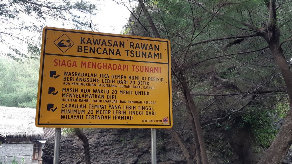 Papan berisi kiat waspada menghadapi tsunami terpampang di kawasan Pantai Serang, Kecamatan Panggungrejo, Kabupaten Blitar, Jawa Timur. Foto diambil 11 Desember 2021.