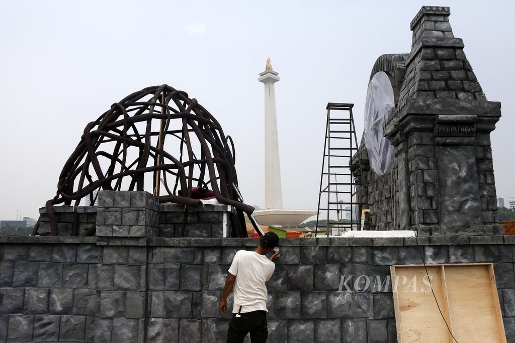 Pekerja menyelesaikan dekorasi untuk mobil hias yang akan digunakan pada acara parade Jakarnaval di malam Tahun Baru di Monas, Jakarta, Rabu (27/12/2023). 