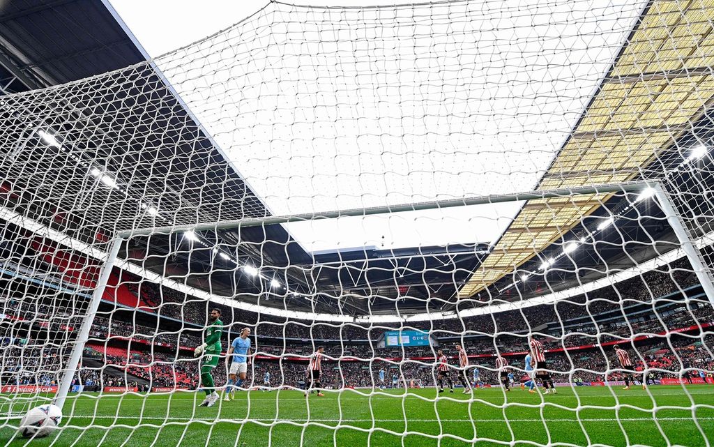 Kiper Sheffield United, Wes Foderingham (kiri), menatap bola yang masuk ke gawangnya saat menghadapi Manchester City pada ajang semifinal Piala FA di Stadion Wembley, London, Inggris, Sabtu (22/4/2023). City menang, 3-0.