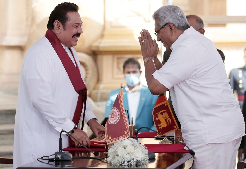Mantan pemimpin Sri Lanka Mahinda Rajapaksa dan saudaranya, Presiden Sri Lanka Gotabaya Rajapaksa memberi isyarat saat pengambilan sumpah di kuil Buddha Kelaniya di Kolombo, Sri Lanka, 9 Agustus 2020. REUTERS/Dinuka Liyanawatte