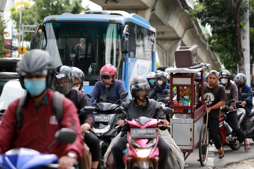 Salah seorang pedagang mendorong gerobak di tengah kemacetan yang terjadi di Jalan Kapten Tendean, Jakarta Selatan, Senin (24/10/2022). Meningkatnya volume kendaraan terjadi pada jam aktif masyarakat untuk pergi dan pulang kantor. 