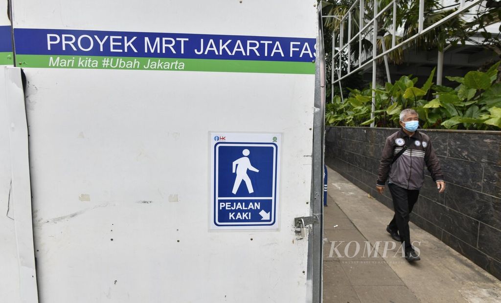 Pejalan kaki menggunakan jalur pedestrian di dekat proyek MRT Jakarta fase 2A paket kontrak (CP) 203 di kawasan Glodok, Jakarta Barat, Rabu (24/11/2021). Proses pembangunan MRT Jakarta fase 2A koridor utara-selatan masih terus berjalan. Paket kontrak 203 (CP203) sebagai salah satu segmen pekerjaan konstruksi dalam MRT Jakarta fase 2A adalah pembangunan Stasiun Glodok dan Stasiun Kota, serta terowongan bawah tanah dari Mangga Besar sampai Kota Tua sepanjang 1,4 kilometer. 