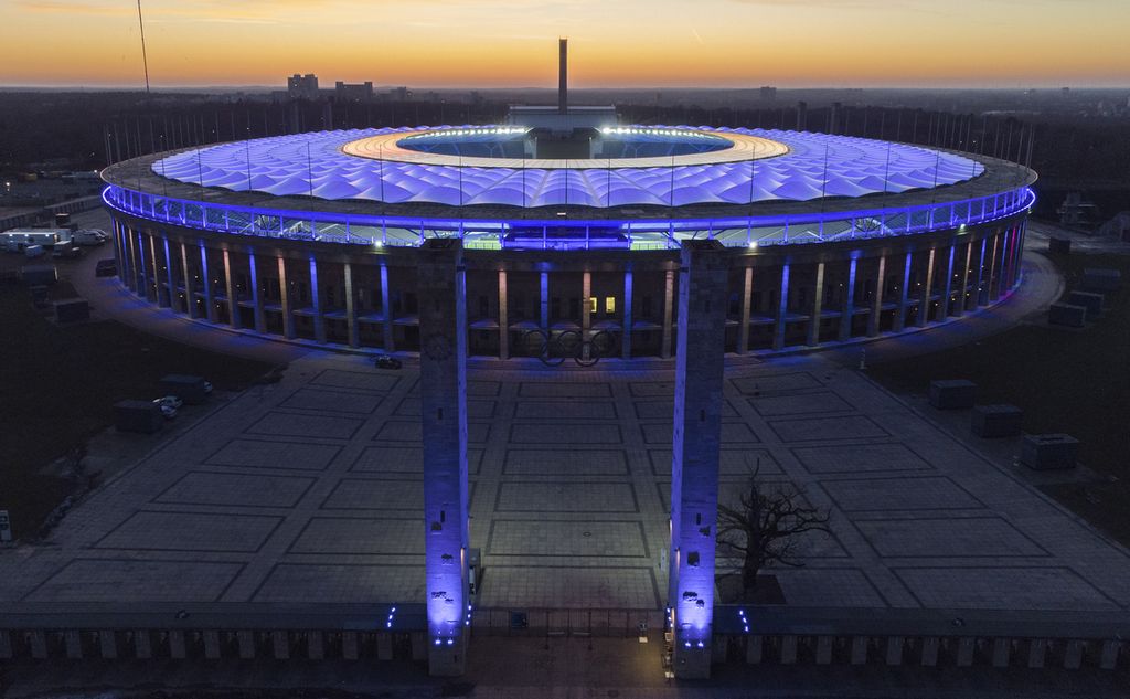 Stadion Olimpiade diterangi lampu saat matahari terbenam setelah pertandingan sepak bola Bundesliga Jerman antara Hertha BSC Berlin dan RB Leipzig di Berlin, Jerman. Saat Spanyol melawan Inggris di final Piala Eropa 2024, mereka akan bermain di stadion yang dibangun oleh Nazi untuk Olimpiade 1936.