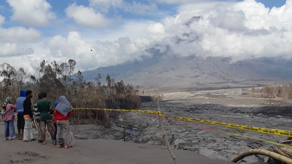 Sekelompok warga berkerumun menyaksikan dampak erupsi Gunung Semeru di pinggir Dusun Umbulan, Desa Supiturang, Kecamatan Pronojiwo, Kabupaten Lumajang, Jawa Timur. Tampak di kejauhan badan Semeru tertutup sebagian oleh awan, Jumat (10/12/2021).