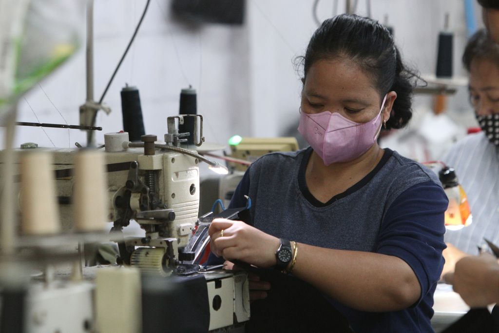 Seorang perempuan pekerja menjahit pakaian di salah satu tempat produksi di kawasan Perkampungan Industri Kecil (PIK) Pulogadung, Jakarta Timur, Kamis (27/10/2022). 
