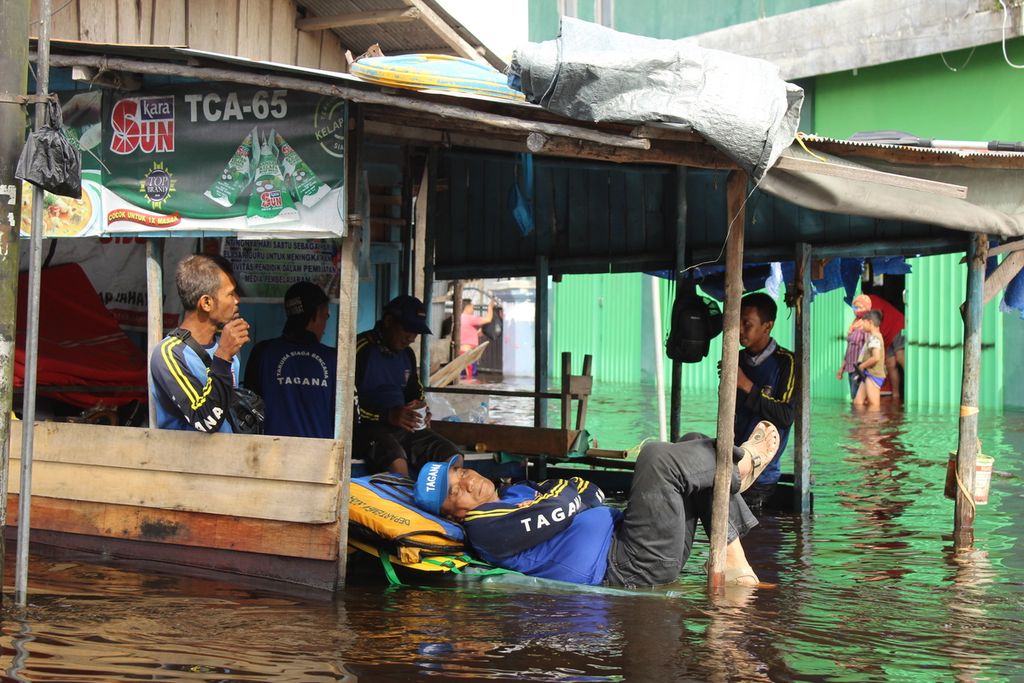 Petugas Tagana Kota Palangkaraya beristirahat setelah selama lebih dari 24 jam mengevakuasi warga yang terdampak banjir di Kelurahan Palangka, Kota Palangkaraya, Kalteng. Selasa (16/11/2021).