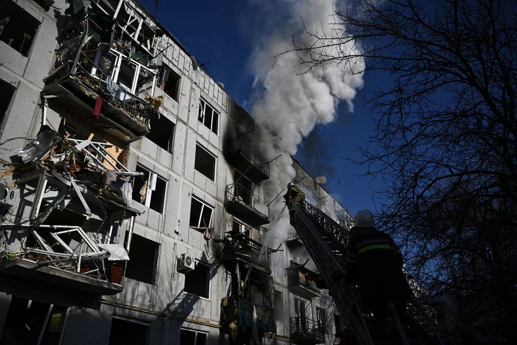 Petugas pemadam kebakaran memadamkan api yang membakar bangunan akibat serangan bom di Chuguiv, 24 Februari 2022. 
