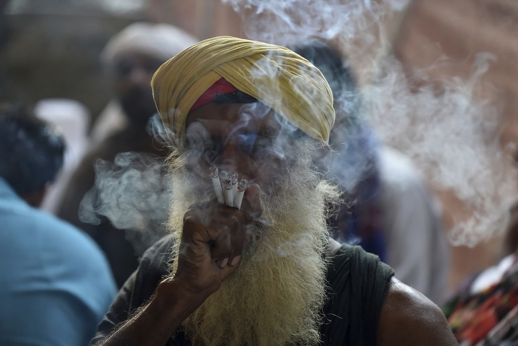 Ilustrasi. Warga merokok beberapa batang sekaligus saat hadir dalam Festival Urs di Kuil Data Darbar, Lahore, Pakistan, Selasa (6/10/2020). 