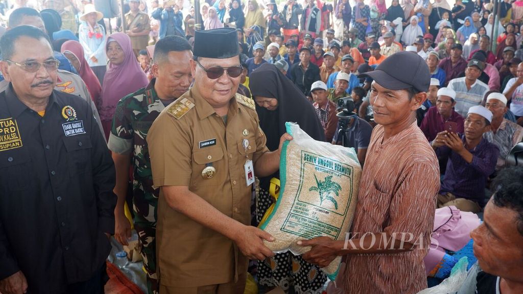 Gubernur Kalimantan Selatan Sahbirin Noor (berkacamata hitam) menyerahkan bantuan benih padi unggul kepada petani di Desa Penggalaman, Kecamatan Martapura Barat, Kabupaten Banjar, Senin (16/10/2023). 