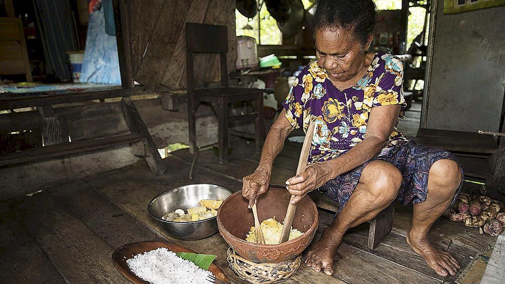 Mama  Wehelmina Monim menumbuk bera yang telah dikupas menjadi seperti getuk
