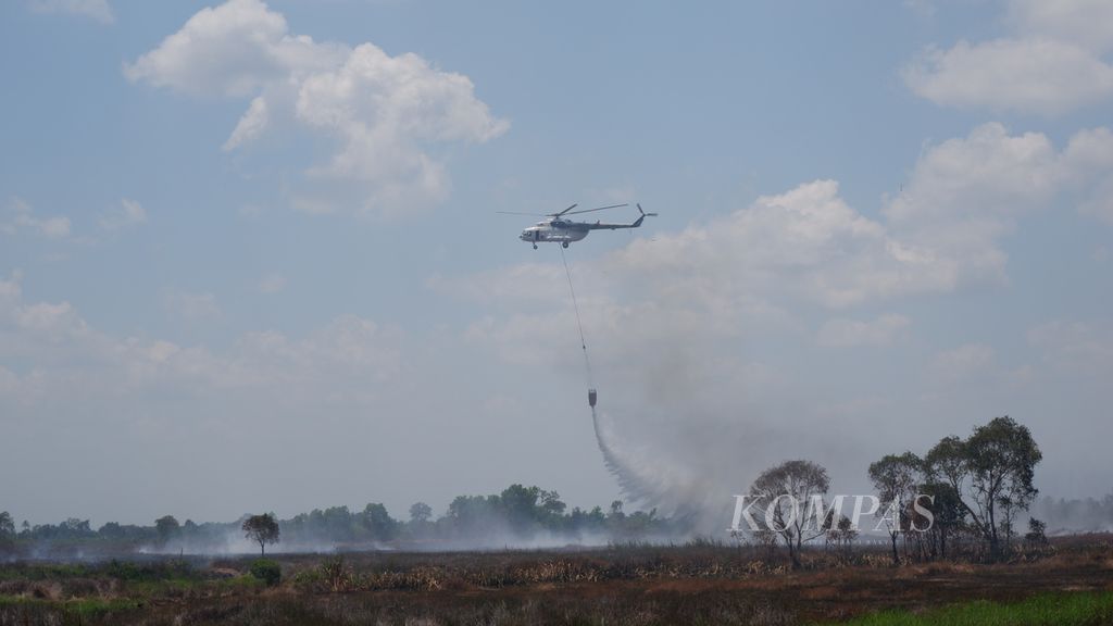 Helikopter pengebom air memadamkan kebakaran lahan gambut di Desa Penggalaman, Kecamatan Martapura Barat, Kabupaten Banjar, Kalimantan Selatan, Kamis (27/9/2018). 